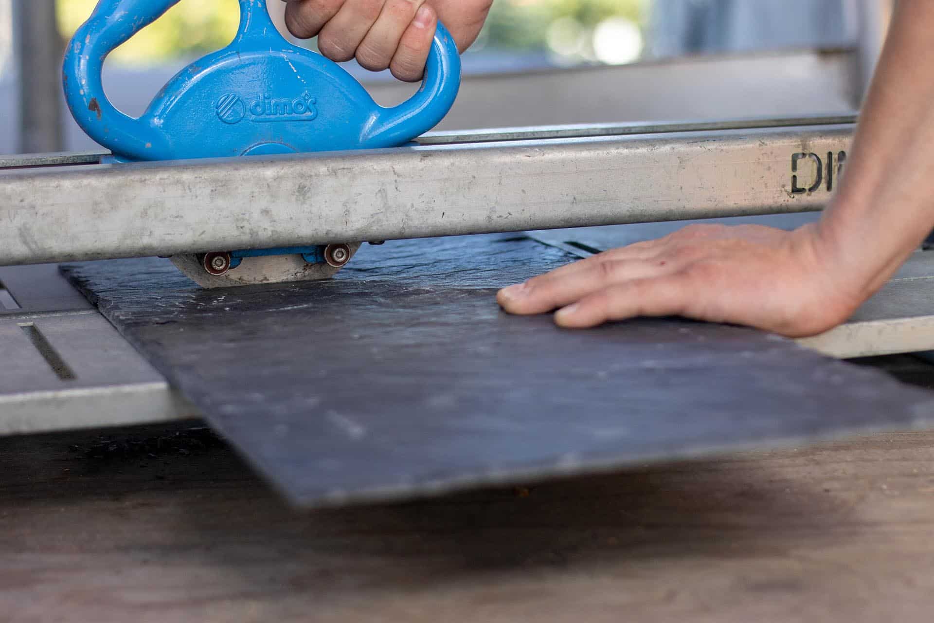 Tilskæring af tagskiferplader, som skal bruges til reparation af skifertag.